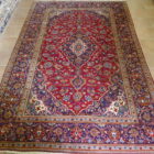 tappeto persiano classico fondo rosso con il medaglione