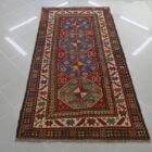 antico tappeto kazak da salotto fondo rosso