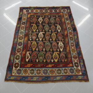 tappeto antico caucasico karabagh kazak con boteh stilizzati e colorati su fondo nero da sala